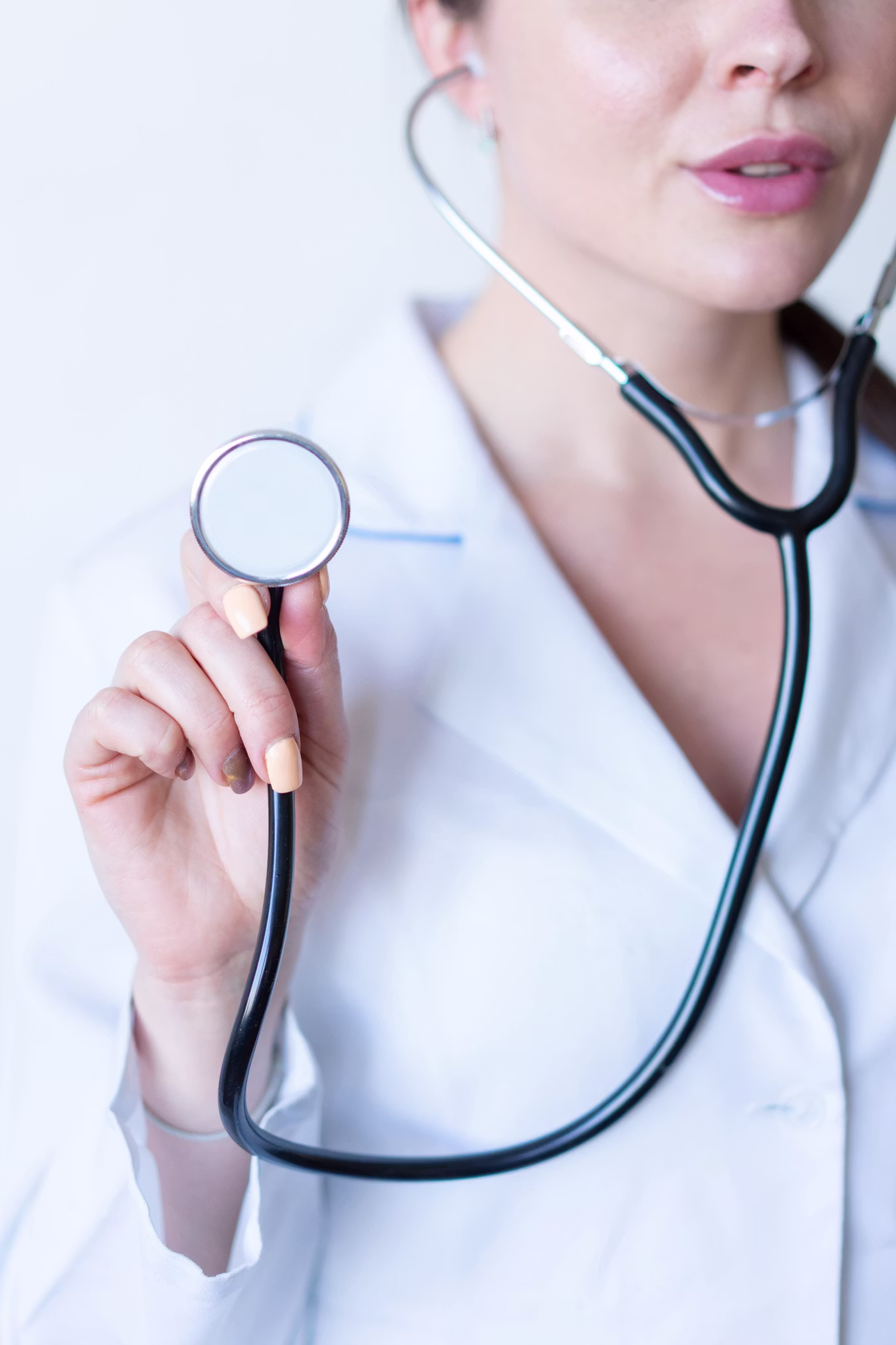 Healthcare professional holding a stethoscope in a modern clinical setting